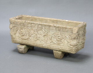 A rectangular concrete garden planter with mask decoration 24cm h x 73cm w x 33cm d 