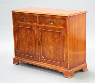 A Georgian style crossbanded mahogany side cabinet fitted 2 drawers above double cupboard enclosed by panelled doors, raised on bracket feet 81cm h x 106cm w x 42cm d (some contact marks)