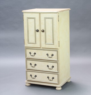 A Victorian style scumble painted cabinet enclosed by panelled doors, the base fitted 3 drawers, raised on bun feet 111cm h x 58cm w x 45cm d  