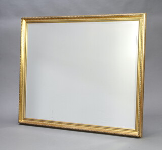 A rectangular bevelled plate wall mirror contained in a decorative gilt frame 129cm x 100cm 