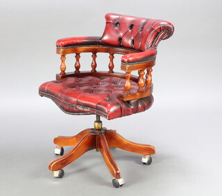 A captain's style revolving office armchair upholstered in red buttoned leather 83cm h x 62cm w x 50cm d (seat 36cm x 43cm) 