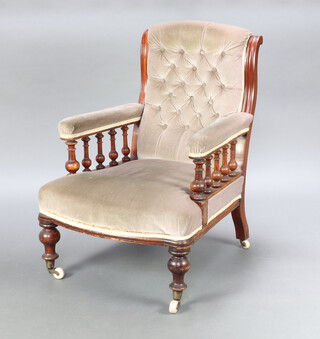 An Edwardian mahogany armchair upholstered in buttoned mushroom coloured material and with bobbin turned decoration to the side, raised on turned supports 92cm h x 68cm w x 64cm d (seat 40cm x 44cm) 
