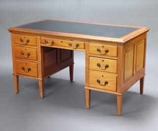 An Edwardian mahogany kneehole desk with inset writing surface above 1 long and 6 short drawers with reeded columns to the side, raised on square tapered supports 75cm h x 137cm w x 75cm d 