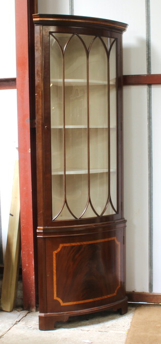 A Georgian style inlaid mahogany double corner cabinet with moulded cornice, fitted shelves enclosed by astragal glazed panelled doors, the base enclosed by an inlaid panelled door, raised on bracket feet 223cm h x 82cm w 56cm d  