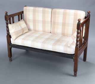 A 1920's oak daybed with bobbin turned decoration raised on turned supports 86cm h x 120cm l x 61cm d 