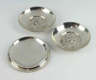 A pair of 800 standard repousse dishes 8.5cm, 55 grams and a silver mounted dish 
