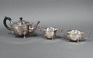 A silver plated 3 piece tea set with ebonised mounts on paw feet 