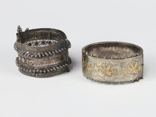 A Victorian 2 colour silver and yellow metal bangle decorated with flowers, an Eastern ditto white metal, 74 grams 
