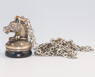 A white metal horses head and hardstone seal 2.5cm on a white metal chain 