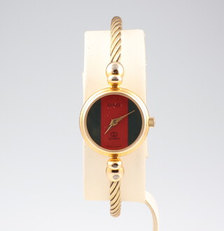 A ladies gilt cased Gucci wrist watch on a sprung bracelet