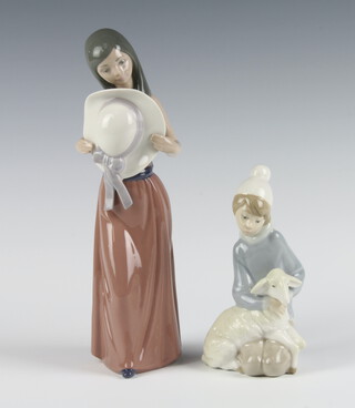 A Lladro figure of a girl holding a hat before her 5007 25cm, a ditto of a boy Shepherd 14cm (f) 