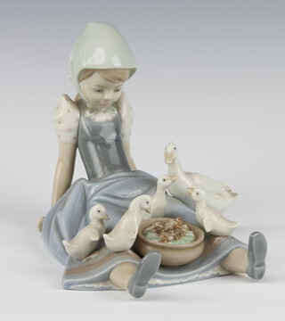 A Lladro figure of a seated goose girl 18cm 