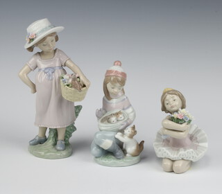 A Lladro figure of a kneeling ballerina 10cm, ditto of a girl with kittens 6020 Friday's child 14cm and a girl carrying a basket of flowers 6826 20cm 