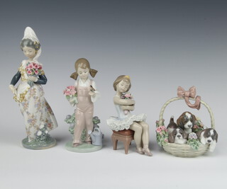 A Lladro figure of a girl holding a bouquet and a bird 18cm 5217, ditto of a ballerina holding a bouquet of flowers 15cm and a Spanish lady holding bouquet of flowers 1304 21cm, ditto basket of puppies 13cm 