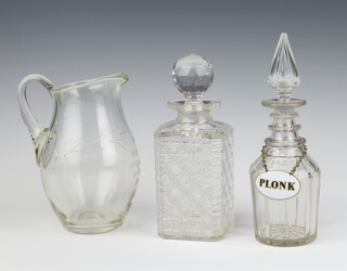 An Edwardian spirit decanter 28cm with enamelled label, a square spirit decanter and a jug 