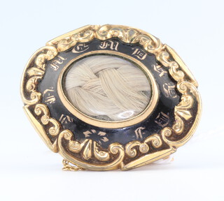 A Victorian gilt and enamelled in memoriam brooch with hair locket 
