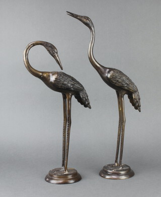 A pair of 20th Century Japanese bronze figures of storks raised on circular bases 52cm h x 12cm 