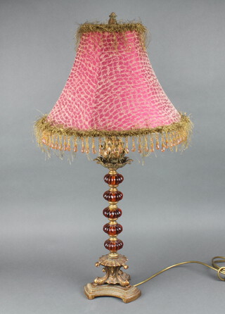 A gilt metal and amber glass Rococo style table lamp raised on a triform base 48cm 