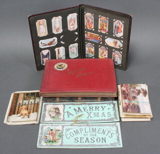 Three albums of cigarette cards including Players, Wills, 2 rectangular cards marked Compliments of the Season and Merry Xmas and a small collection of black and white and coloured postcards

