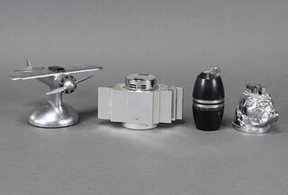 A 1930's Demley chrome table lighter in the form of an aircraft 8cm x 14cm x 16cm, a lighter in the form of a Bulldog's head 6cm x 6cm x 4cm, a 1960's chrome sculptural shaped table lighter 7cm x 13cm x 6cm and The Decca Navigator table lighter  