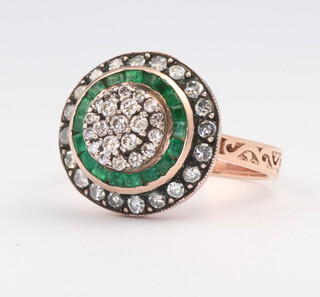 A yellow metal rose coloured emerald and diamond target ring, size P, 6.5 grams