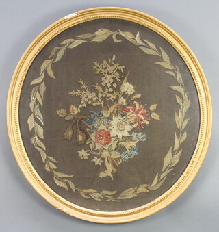 A Victorian oval woolwork picture, floral study within laurel leaves, contained in a decorative gilt frame 68cm x 65cm 