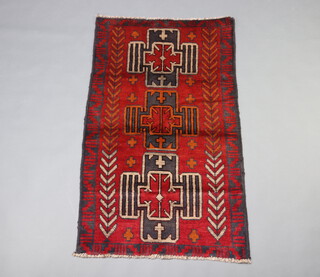 A red and black ground Belouch rug with 3 stylised medallions to the centre 140cm x 83cm 