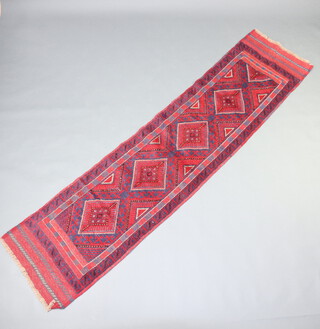 A red and blue ground Meswani runner with 4 diamonds to the centre 250cm x 70cm 
