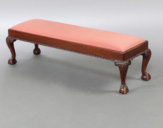 An Edwardian Chippendale style rectangular mahogany footstool with upholstered drop in seat, raised on cabriole ball and claw supports 30cm h x 99cm w x 34cm d 