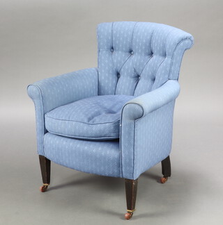 An Edwardian armchair upholstered in blue buttoned material raised on square tapered supports ending in ceramic casters 82cm h x 70cm w x 53cm d 