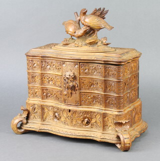 A 19th Century Black Forest carved trinket box, the hinged lid surmounted by 2 carved figures of pheasants revealing 6 hinged compartments and with void to base, raised on scroll supports 30cm h x 30cm w x 18cm d 
