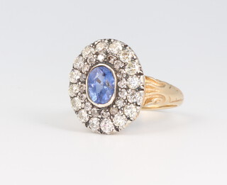 A white and yellow metal stamped 15 oval sapphire and diamond cluster ring, the centre stone 1.5ct surrounded by brilliant cut diamonds approx. 1.1ct, 4.2 grams, size N 