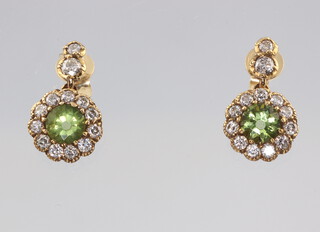 A pair of yellow metal 18ct peridot and diamond cluster earrings, the 2 centre stones approx. 1.0ct, the brilliant cut diamonds 0.9ct, 2.5 grams, 8mm