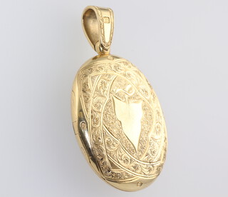 A yellow metal 18ct oval engraved locket with vacant cartouche, gross weight 19.4 grams 
