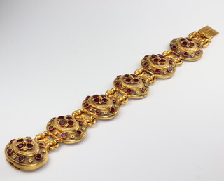 A Victorian yellow metal garnet set 6 plaque bracelet 19cm, 51.2 grams gross, the backs are inlaid with mother of pearl panels (1 a/f)