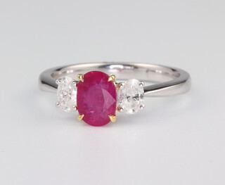 A white metal 18ct oval ruby and diamond ring, the centre stone 1.04ct, the 2 brilliant cut diamonds 0.4ct, 4 grams, size N 