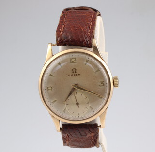 A gentleman's 9ct yellow gold Omega wristwatch with seconds at 6 o'clock, contained in a 59mm case, on a leather strap 