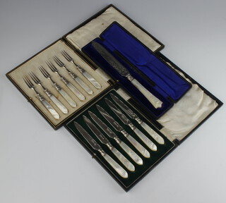 An Edwardian mother of pearl mounted silver bread knife Sheffield 1907, a cased set of ditto dessert forks and a set of butter knives 
