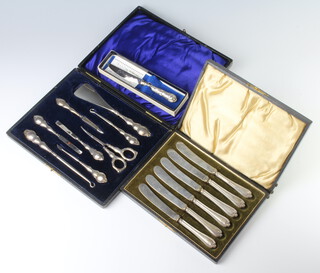 An Edwardian cased silver accessories set (8), together with a cased set of tea knives and a butter knife 