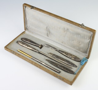 A Continental white metal repousse desk set (6), cased with floral decoration 