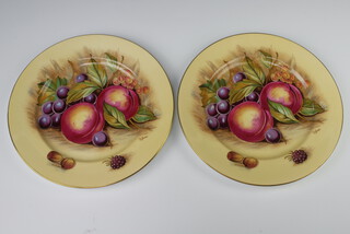 Aynsley, a pair of plates decorated peaches and grapes, 26.5cm signed D James