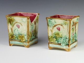 A pair of Victorian Majolica square twin handled urns with floral decoration, raised on panelled feet 16cm h x 13cm x 13cm 