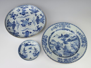 An 18th Century Chinese blue and white plate decorated with a landscape 29cm (cracked), a ditto shallow dish decorated with flowers 28cm and a small dish decorated with a riverscape 14cm (cracked)