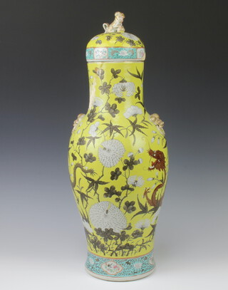 A 19th Century Chinese yellow ground oviform vase decorated with scrolling dragons and chrysanthemum, with lion ring mask handles and shi shi finial 66cm h 