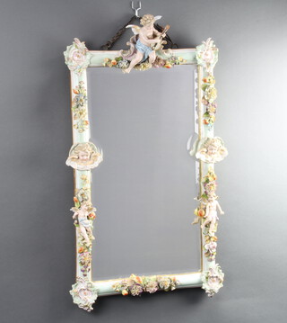A late 19th Century German porcelain mirror frame decorated with cherubs and applied flowers 76cm 