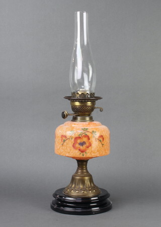 A Victorian oil lamp with orange, opaque and floral patterned reservoir, raised on a gilt and black ceramic socle base complete with chimney, 58cm h x 17cm diam. 