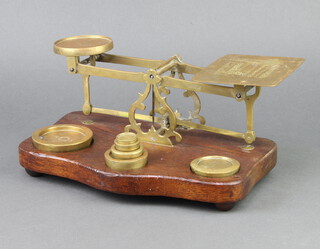 A pair of 19th Century brass letter scales, raised on an oak base together with 6 brass weights, 1 marked Borough of Huddersfield 
