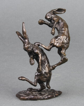 In the manner of Richard Cooper & Co., an unmarked figure group of 2 boxing hares, raised on an oval base 10cm x 5cm x 3cm 