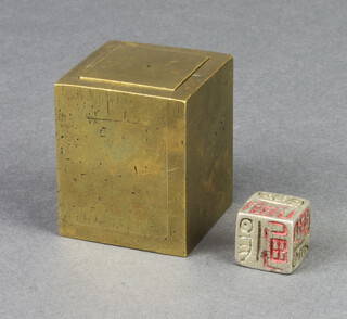 An Eastern metal dice contained within a polished bronze cube 5cm x 4cm x 4cm 