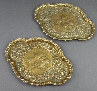 A pair of shaped embossed brass dressing table trays decorated Reynolds Angel 28cm x 20cm